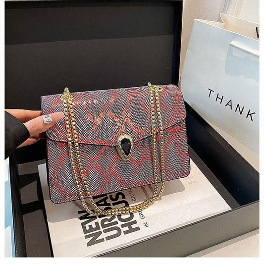 Sac à bandoulière motif python avec chaîne dorée